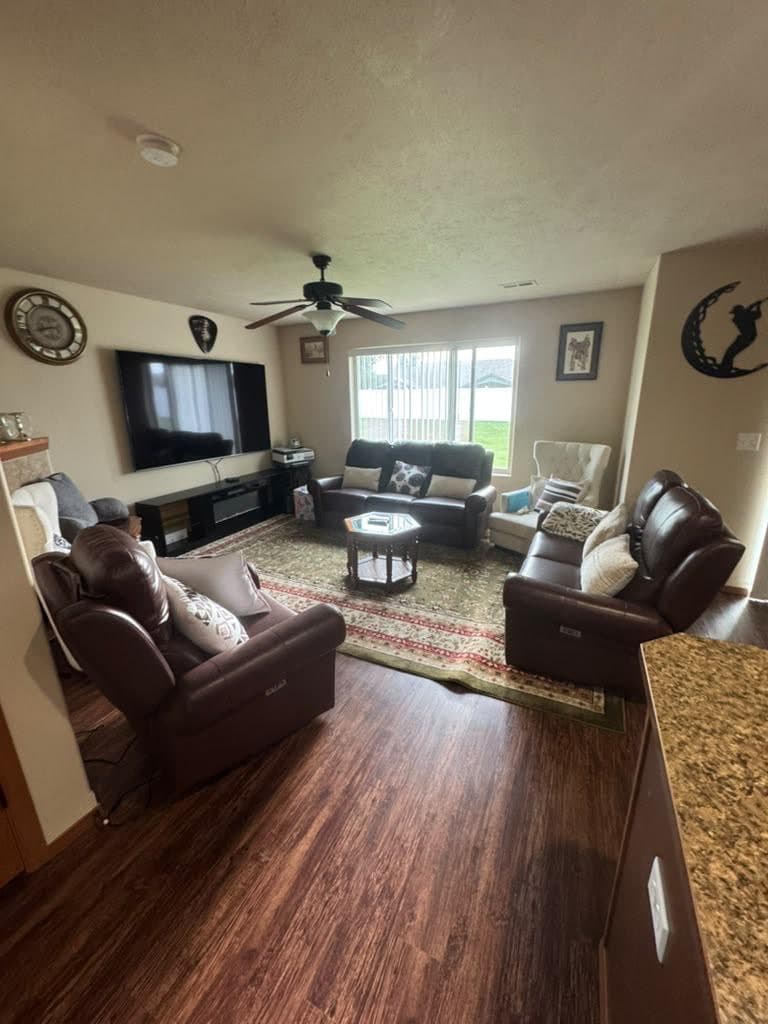 Living room with leather recliners, a large TV and a patterned rug