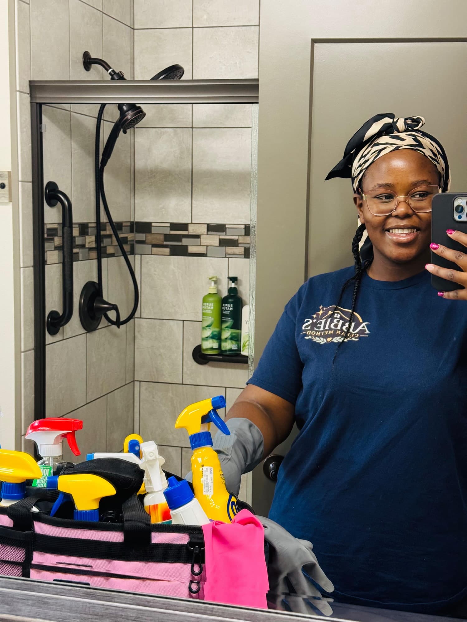 Abbie in an Abbie's Clean Method shirt with her cleaning caddy